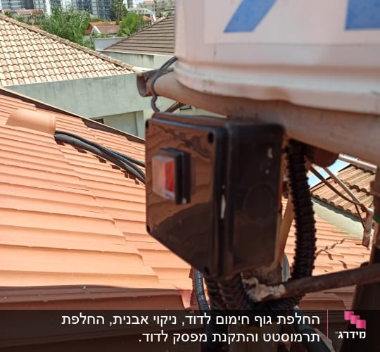 דוד שמש על גג עם צינורות וחיבורים חשמליים